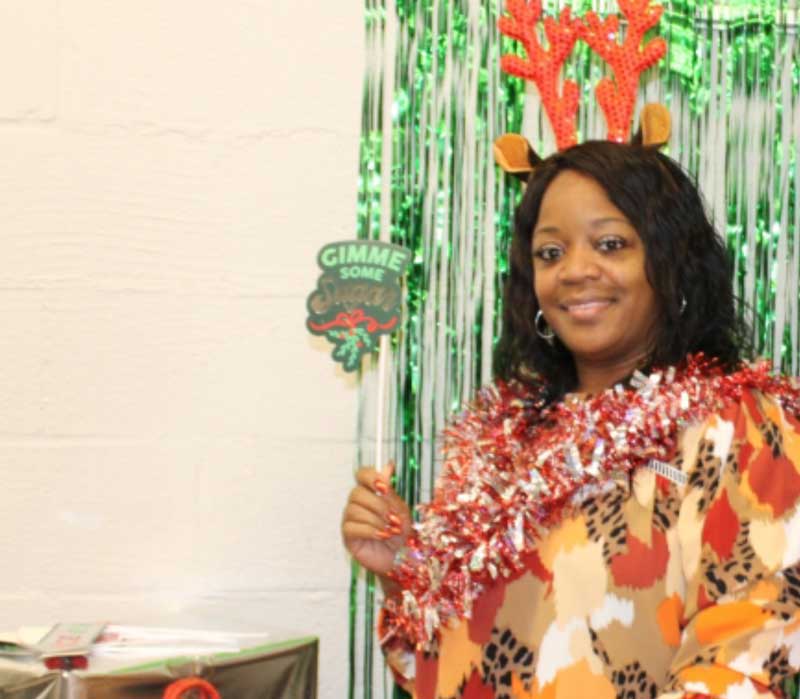 Woman standing in front of Christmas party backdrop