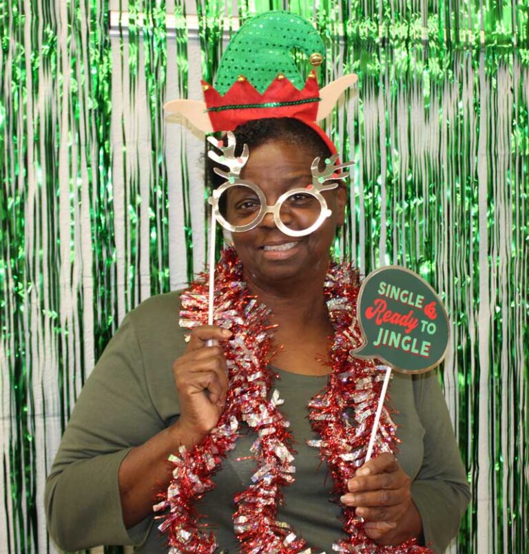 Woman standing in front of Christmas party backdrop