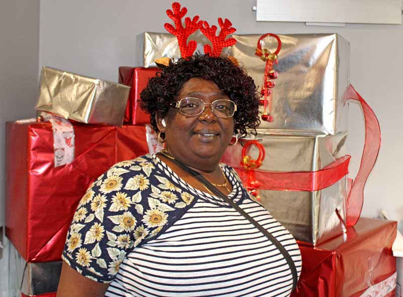 Woman standing in front of Christmas present backdrop