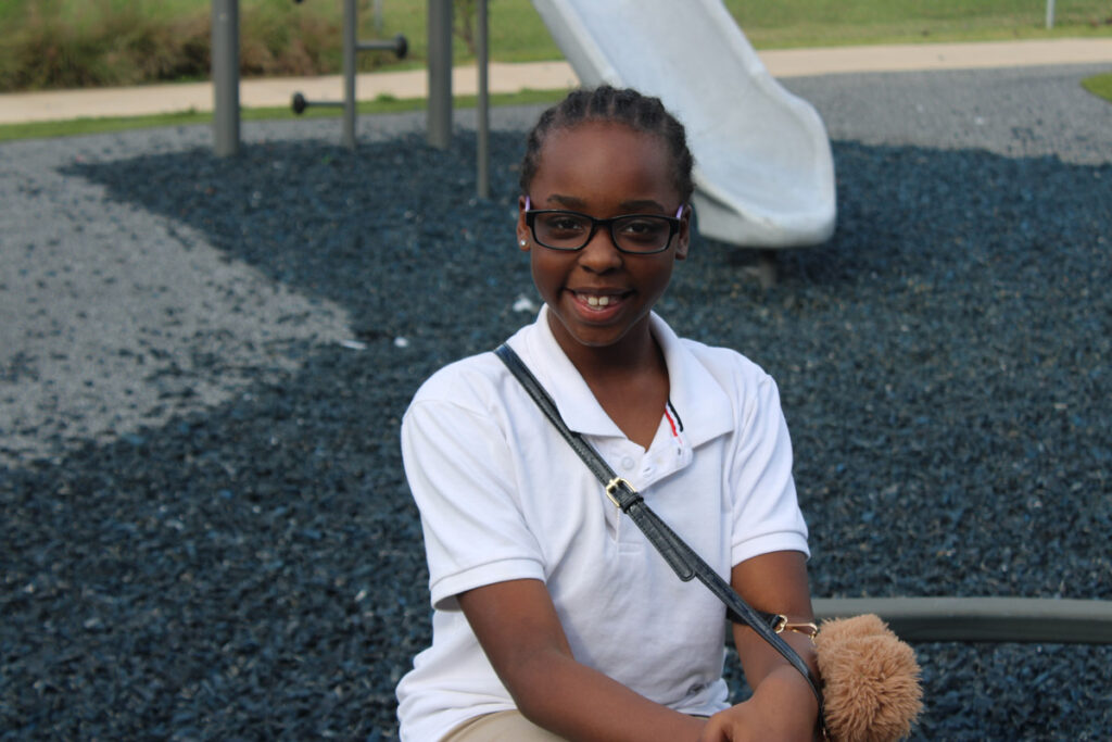 a 4th-grade girl sitting at a playground